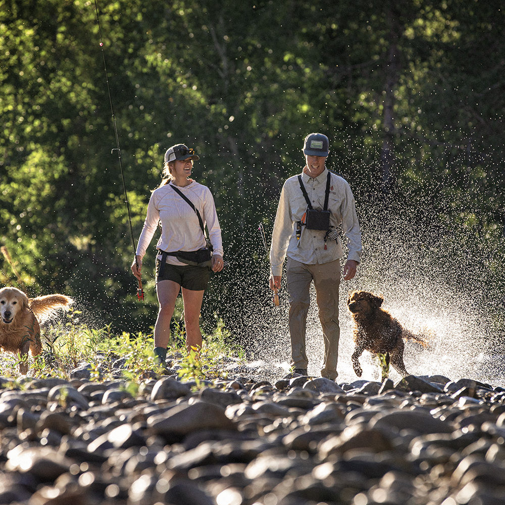 two anglers at river's edge with two golden retrievers fly fishing in Sun Valley, Idaho | Silver Creek Outfitters